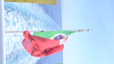 The italy flag flutters in the wind. The symbol of italy on board a ship at sea. High quality FullHD footage . Vertical