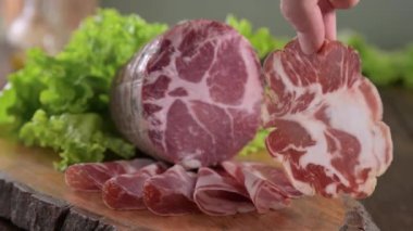 Capocollo or coppa is a traditional Italian and Corsican pork cut made from cured pork shoulder or neck. . Cut into very thin slices. Italian delicacy for aperitivo. Piacentina DOP. 4k footage