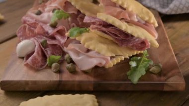 Hilal çiçeği. Emilia Romagna bölgesinin yiyeceği, kızarmış ekmek gnocco fritto ya da Crescentina. İtalya 'da aperatif veya aperatif. Prosciutto crudo, mortadella, Milano salamı, kapari, peynir ile Creshantina 