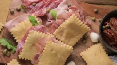 Hilal çiçeği. Emilia Romagna bölgesinin yiyeceği, kızarmış ekmek gnocco fritto ya da Crescentina. İtalya 'da aperatif veya aperatif. Prosciutto crudo, mortadella, Milano salamı, kapari, peynir ile Creshantina 