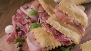 Hilal çiçeği. Emilia Romagna bölgesinin yiyeceği, kızarmış ekmek gnocco fritto ya da Crescentina. İtalya 'da aperatif veya aperatif. Prosciutto crudo, mortadella, Milano salamı, kapari, peynir ile Creshantina 