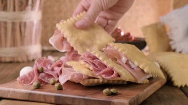 Hilal çiçeği. Emilia Romagna bölgesinin yiyeceği, kızarmış ekmek gnocco fritto ya da Crescentina. İtalya 'da aperatif veya aperatif. Prosciutto crudo, mortadella, Milano salamı, kapari, peynir ile Creshantina 