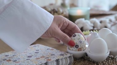 Paskalya yumurtaları ellerinde bir desenle, dişi eller Paskalya geleneksel aile dini bayramı için yumurtaları süslüyor. Yüksek kalite 4k görüntü