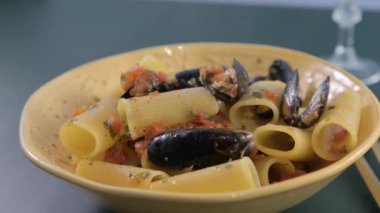 İtalyan makarna Paccheri allo scoglio ve midye. Soslu karides ve midyeli büyük İtalyan makarnası. Güney İtalya 'dan, tipik deniz mahsullü Napoli makarnası. Yüksek kalite 4k görüntü