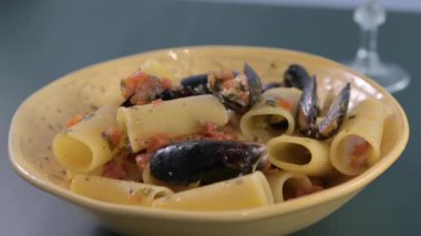 İtalyan makarna Paccheri allo scoglio ve midye. Soslu karides ve midyeli büyük İtalyan makarnası. Güney İtalya 'dan, tipik deniz mahsullü Napoli makarnası. Yüksek kalite 4k görüntü