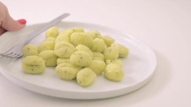 İtalyan gnocchi. Geleneksel İtalyan yemekleri. Parmesanlı ve fesleğenli el yapımı patates topları. Vejetaryenler için yemek ve tipik İtalyan mutfağı aşıkları. Ev yapımı makarna. Yüksek kalite 4k görüntü