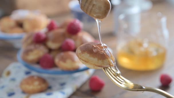 フォークの上に黄金のオランダのポファルテスが閉じ込められています プレートの上の美味しい伝統的なミニパンケーキ 青いパターンを持つ白いプレートのミニパンケーキ — ストック動画