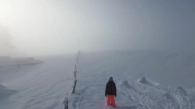 Yol sisli ve bir kız yukarıdan karda oynuyor, bir kuadkopterde çekiliyor. Yukarıdan nefes kesen kış İsviçre 'si deneyimi. Görüntüler 4k kuadkopterinden alındı