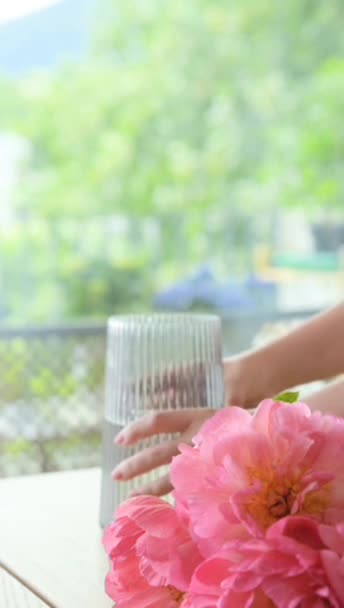 모란의 꽃다발 여자는 테이블에 거실에 소다와 꽃병에 분홍색 모란을 넣습니다 — 비디오