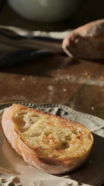 버터와 프랑스어 바게트 버터로 신선한 브러시타 아침에 태양에 테이블에 향기로운 — 비디오