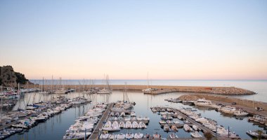 Sunset Tranquil Sahil Manzarası 'nda Yat ve Teknelerle Sahne Marina. Gün batımında güzel marina sahnesi, kıyıya yanaşmış yatlar ve tekneler. Yüksek kalite fotoğraf