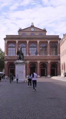 Rimini, İtalya 'daki tarihi bina, önünde bir heykel ve yürüyen insanlar. İtalyan mimarisi, kültürü ve mirasının sergilendiği güzel bir seyahat merkezi.. 