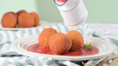 Yakın plan çekimler Sicilya arancini 'sini pirinç, peynir ve otlarla kırıyor. Kıtır kıtır ve tuzlu dolgu. Geleneksel İtalyan sokak yemekleri. Yüksek kaliteli FullHD görüntüler