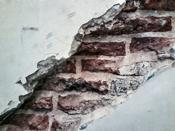 Yakın çekim, kırık beyaz duvar, üstü açık tuğla duvar yüzeyi.