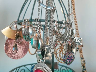 Rings, necklaces and bracelets at desk hanger close up interior shot