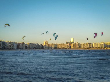 Montevideo, Uruguay 'daki ünlü Pocitos Sahili' nde uçurtma sörfü yapan bir grup insan.
