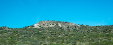 Small mountain and clean blue sky at background at patagonian steepe landscape environment,  trelew, chubut province, argentina clipart