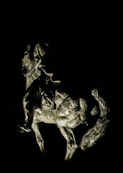 stock image Man on horse sculpture high contrast scene image over black background