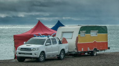 Karavan ve arabalar Cerro avanzado plajı sınırında, Puerto Medresesi, Chubut Bölgesi, Arjantin