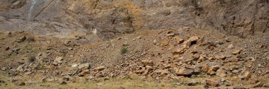 Dry arid ground and base of rocky mountain at la buitrera canyon, piedra parada, patagonia, chubut province, argentina  clipart