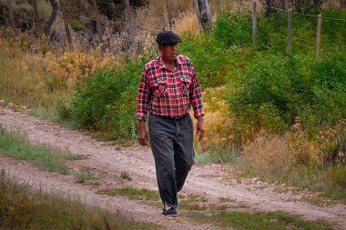 Los Altares, Arjantin: 10 Ocak 2023: Toprak yolda yürüyen kıdemli kırsal işçiler Meadow Peyzaj, los altares, Chubut Eyaleti, patagonya, Arjantin