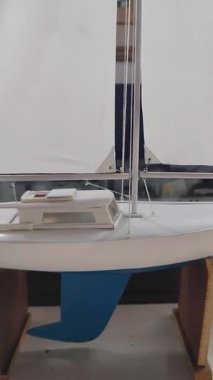 İç mekan odasındaki masanın üzerinde bulunan küçük ölçekli ahşap bir yelkenli minyatürü gösteren bir video.
