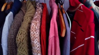 Yetişkin bir adamın gardırobundan soldan sağa doğru çekilen orta ölçekli görüntüler. Hem yaz hem de kış mevsimleri için kıyafetler sergileniyor.. 