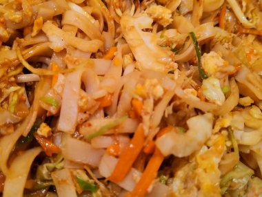 Karışık sebzeli kızarmış şehriye tabağının yüksek açılı yakın çekimi. Yemek renkli, iyi pişmiş ve sıcak servis edilmiş. Asya mutfağı etkisi.