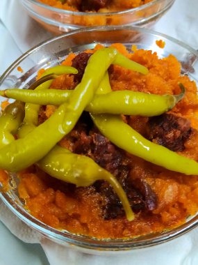 Chorizo soslu, kızarmış yeşil biberli ve ançüezli geleneksel İspanyol migasıyla dolu iki cam kasenin önü..