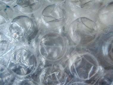 Şeffaf baloncuk ambalajının aşırı yakın görüntüsü. Tekrarlanan dairesel desen ve parlak plastik yüzey koruma, yastık ve malzeme soyutlamasını iletir