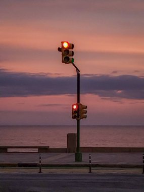 Gün batımında, Montevideo City, Uruguay 'da deniz kenarında trafik ışığı parlıyor.