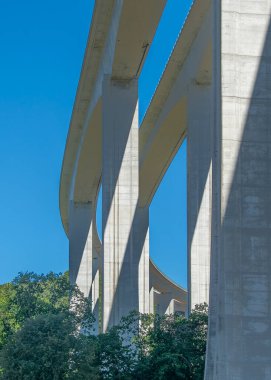 Uzun beton bir viyadük köprüsünün alçak açılı çekimi. Orman manzarası boyunca uzanan, vila gerçek, Portekiz...