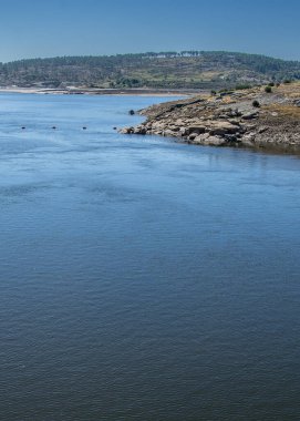  Kuru bir vadiyi geçen bir nehrin geniş bir görüntüsü, tepelerle çevrili..
