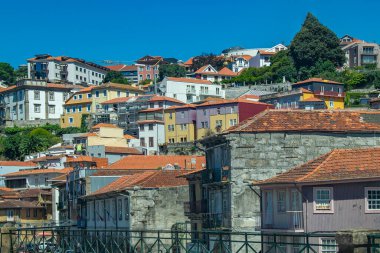 Porto yamacının geniş açılı görüntüsü terracotta çatısı olan geleneksel evlerle dolu, gün ışığı altında katmanlar halinde dizilmiş..