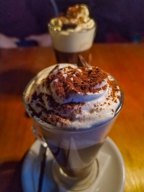 Yüksek açılı ön manzara. Uzun, zarif bir bardakta çikolatalı frappe ya da milkshake 'in yakın çekimi..