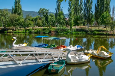 Tamega Nehri Parkı 'ndaki küçük rıhtıma park etmiş tekneler. Tamega Nehri manzaralı turistik bir park. Chaves City, Portekiz' in tarihi merkezinde yer alıyor.