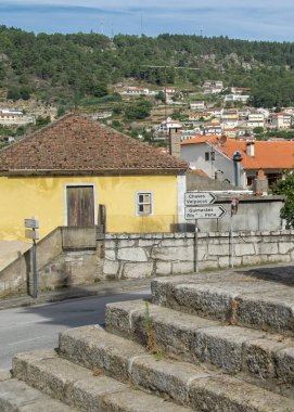 Wide shot of stone stairs in vila pouca do aguiar historic center with city and rooftops in background under daylight	