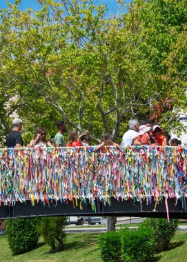 Aveiro, Portugal: August 15 2023: Wide shot of colorful ribbon covered bridge over a canal in Aveiro Portugal symbolizing love and hope under daylight