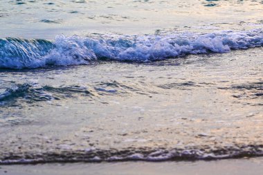 Gün batımında deniz suyu ve kum