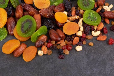 Siyah bir arka planda kuru meyveler.