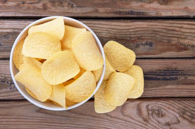 Tahta bir yüzeyde patates cipsi.