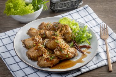 Ahşap masada demirhindi soslu kızarmış tavuk.