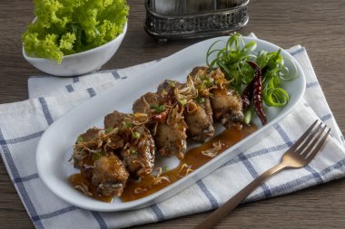 Ahşap masada demirhindi soslu kızarmış tavuk.