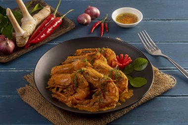 Tahta masada karidesle kızartılmış kırmızı köri Tayland usulü yemek.