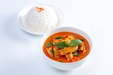 Beyaz arka planda kırmızı körili tavuk ve pirinç.. 