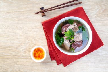 Tahta bir masada beyaz bir kasede domuz kanı çorbası.
