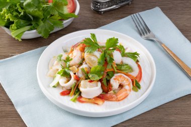 Baharatlı deniz ürünleri salatası, Tayland baharatlı yemek tarifi masa tahtasında baharatlı deniz ürünleri.