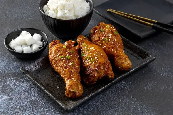 Tahta masada siyah tabakta Kore soslu kızarmış tavuk.