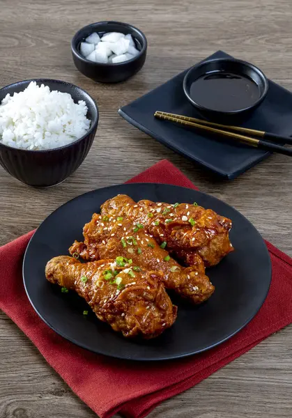 Tahta masada siyah tabakta Kore soslu kızarmış tavuk.