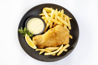 balık ve patates kızartması ve tartar sosuyla servis edilen dilimlenmiş limon beyaz arka planda izole edilmiş tabakta..